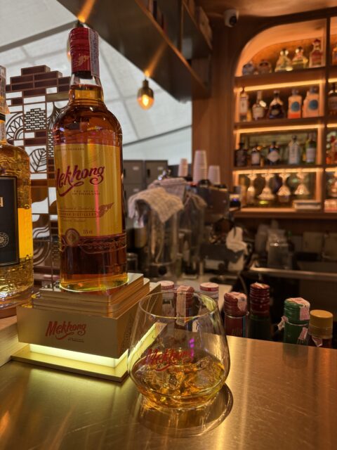 空港のバーでメコンウイスキーとタイの砂糖キビから造られたジンを飲む